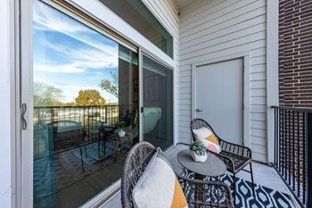 A patio with two chairs and a table on a balcony